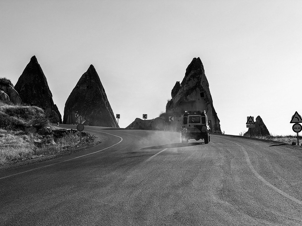 Vehicle driving along a road between the fairy chimneys of Cappadocia, Turkey