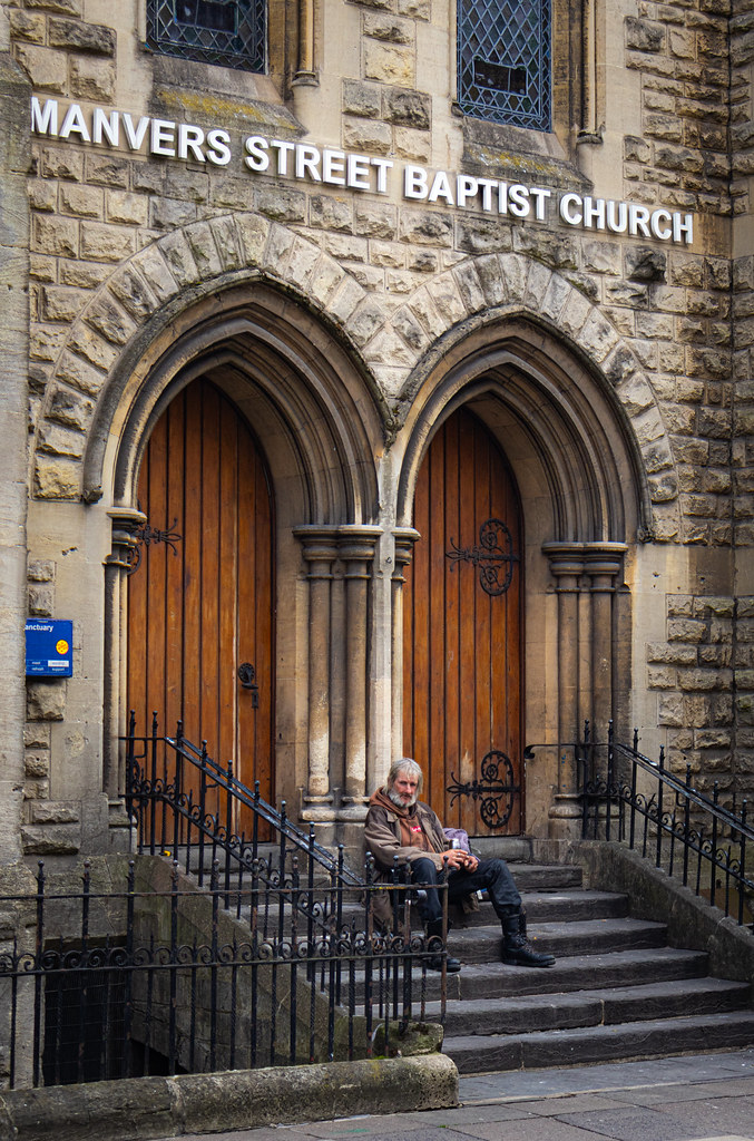 Man sitting on the steps of Manvers Street Baptist Church in Bath