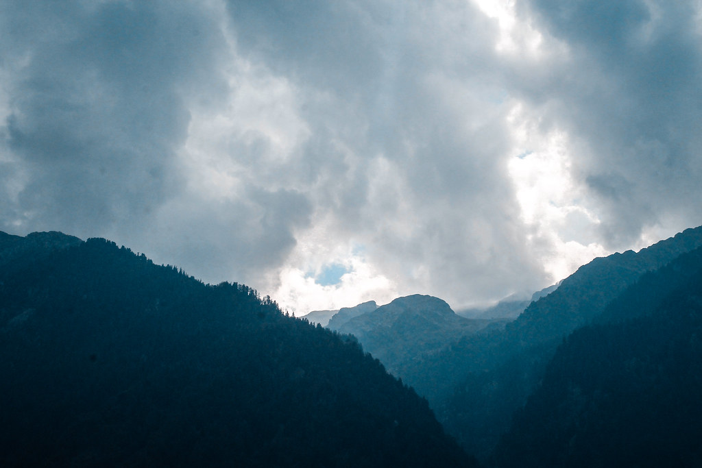Storm clouds breaking over dark mountain ridges in Kashmir